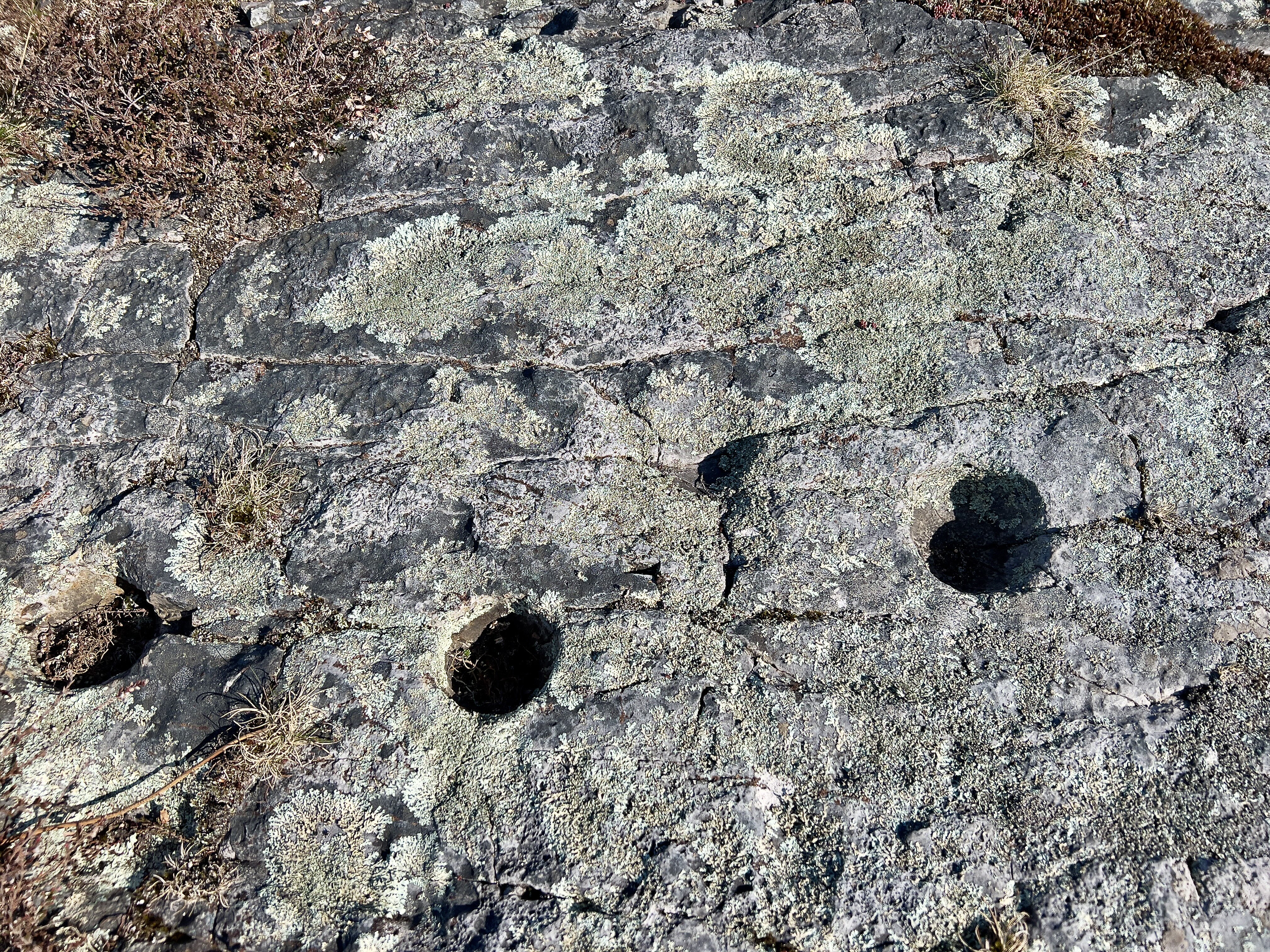 Clear cup marks on the stone above the burial chambers. 