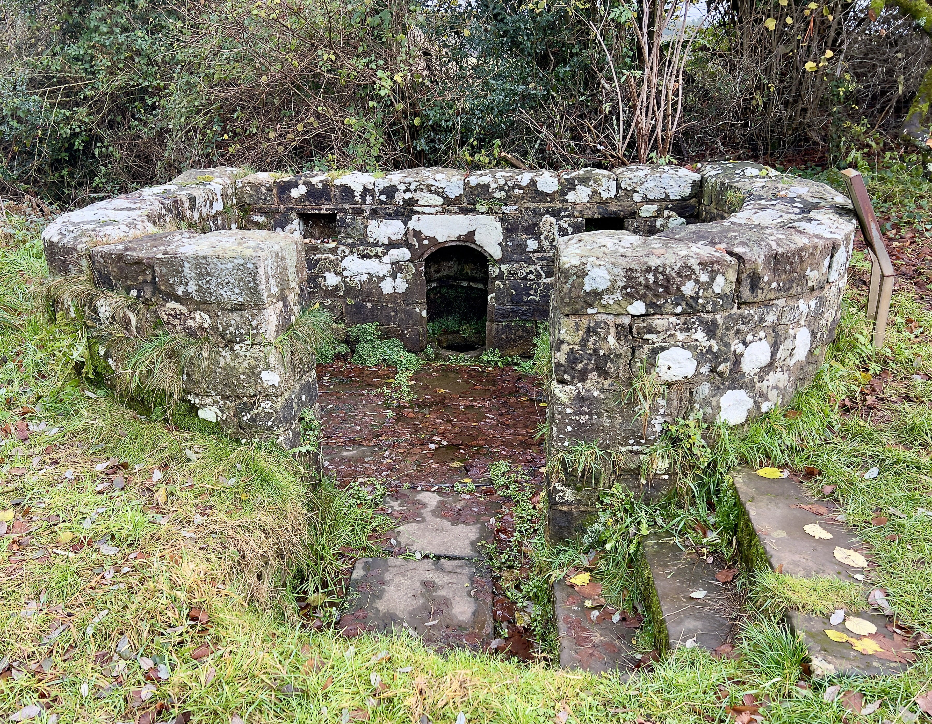 The surrounding stone wall encloses the well, almost seeming to protect it from outside influxes.